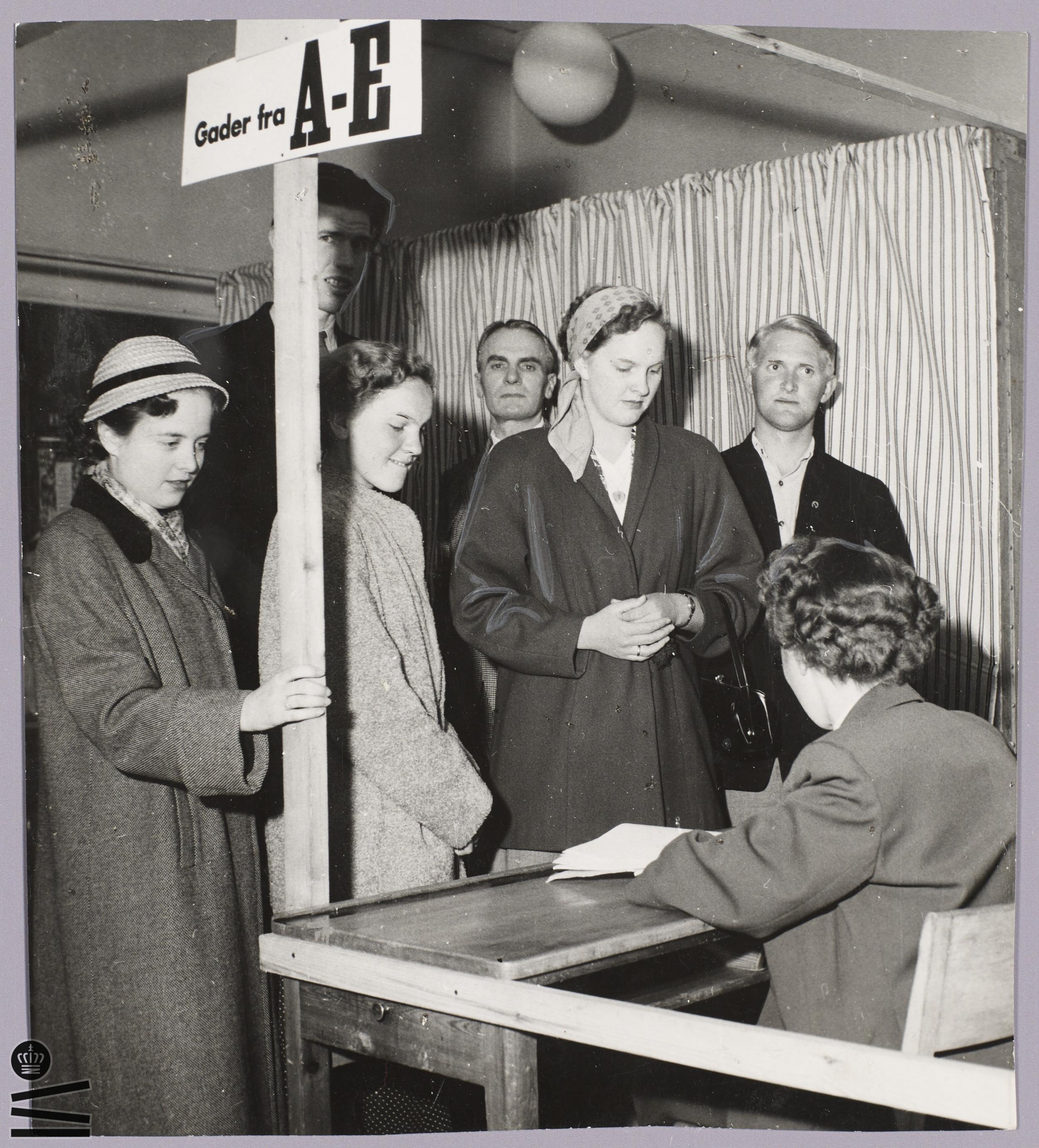 Women are given their ballot papers at the polling station