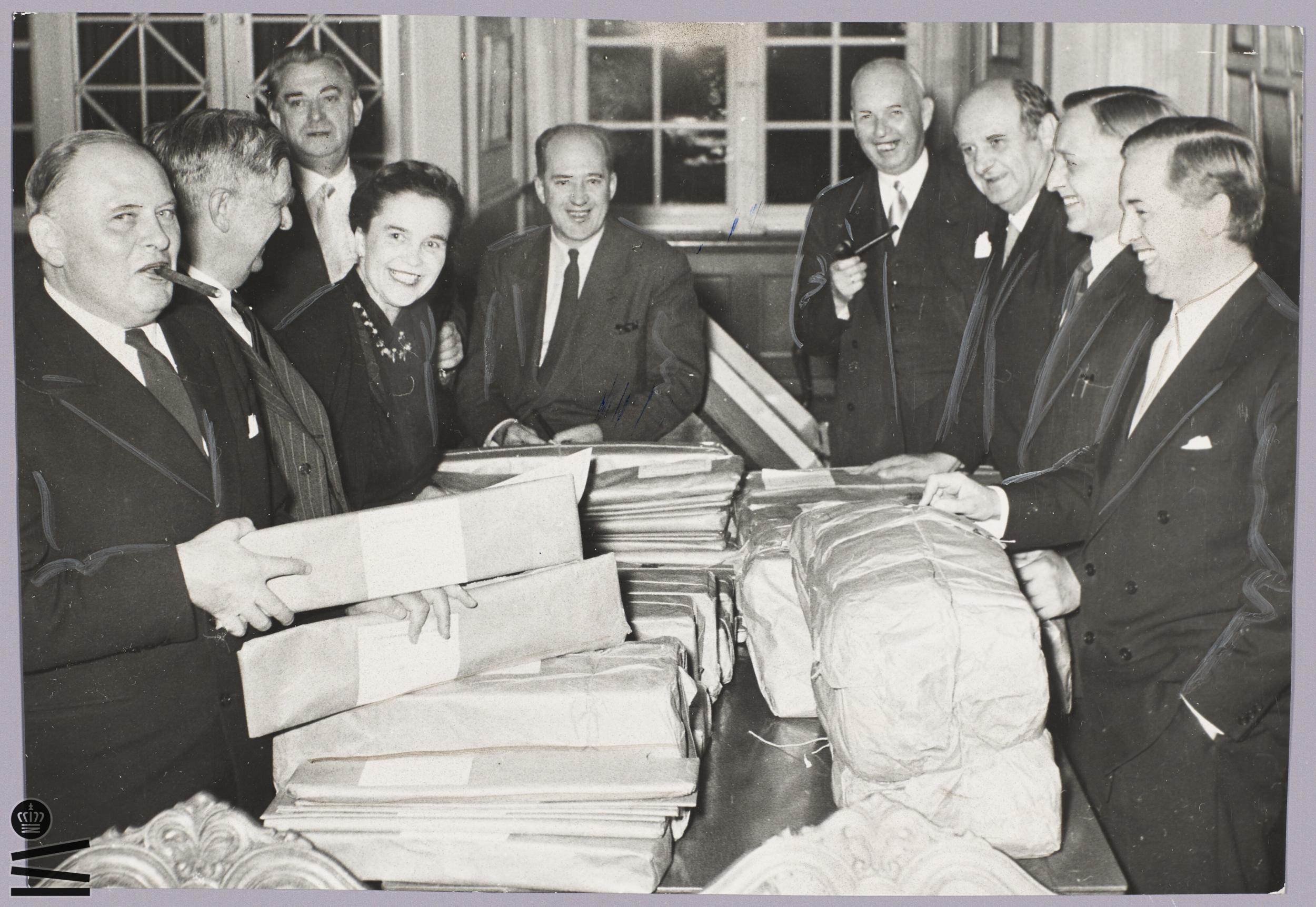 Men and a woman count votes around a large table