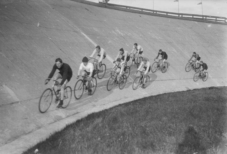 Fotografi af en gruppe mænd, der er i fært med banecykling.