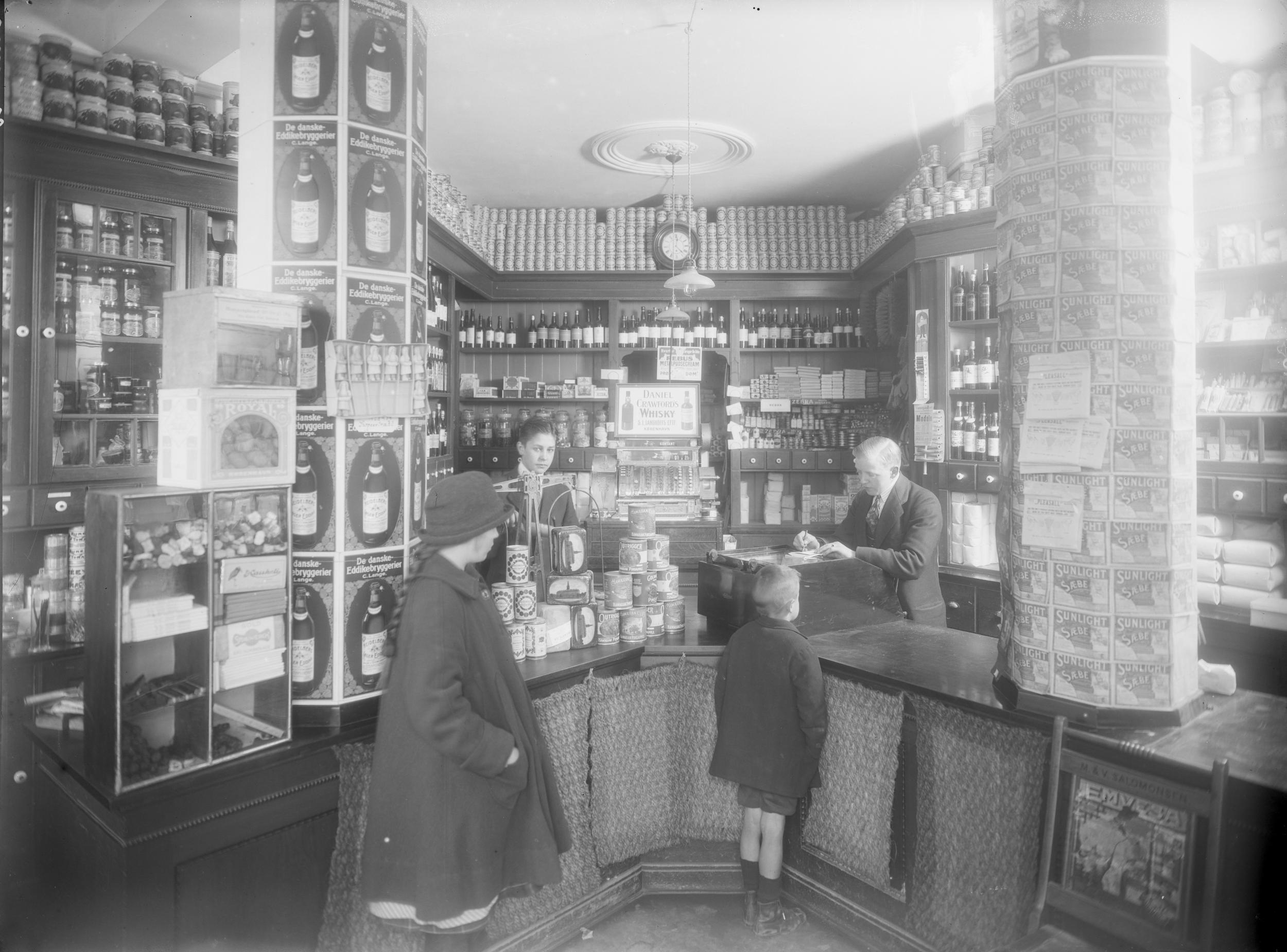 En lille dreng bliver betjent i en købmandsforretning