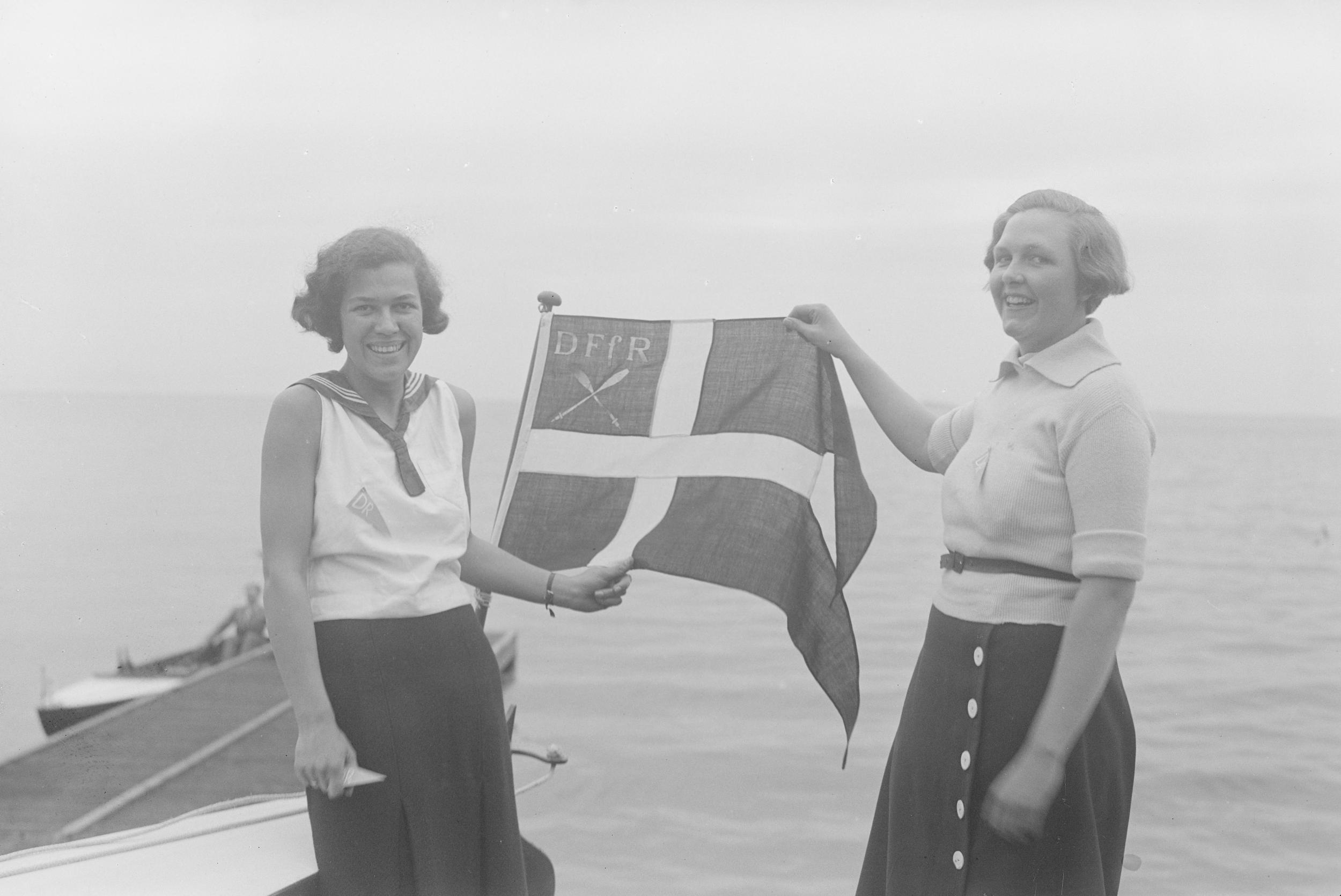 To kvinder holder det danske flag oppe hvor der står DFFR