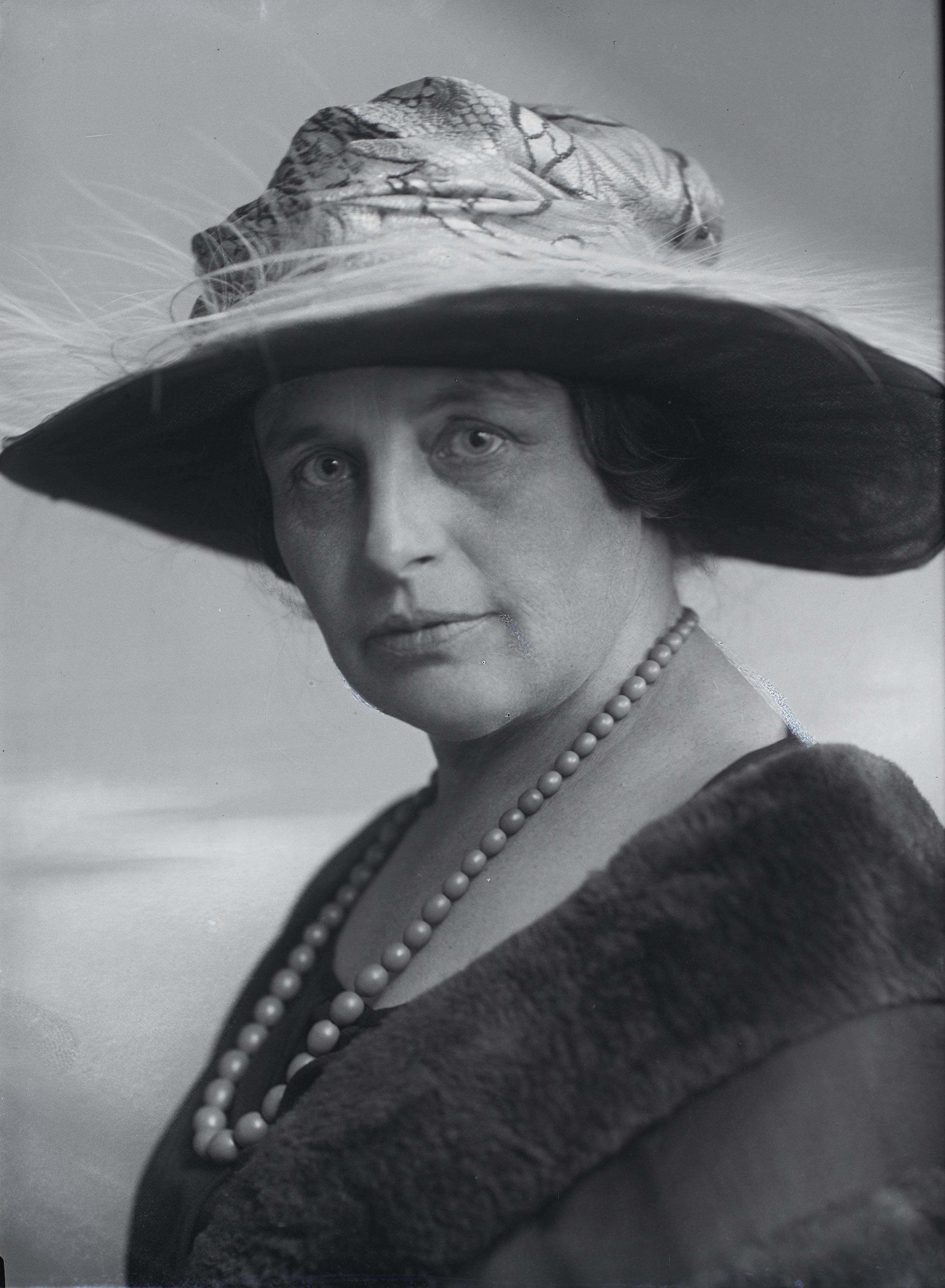 Woman wearing pearls and hat