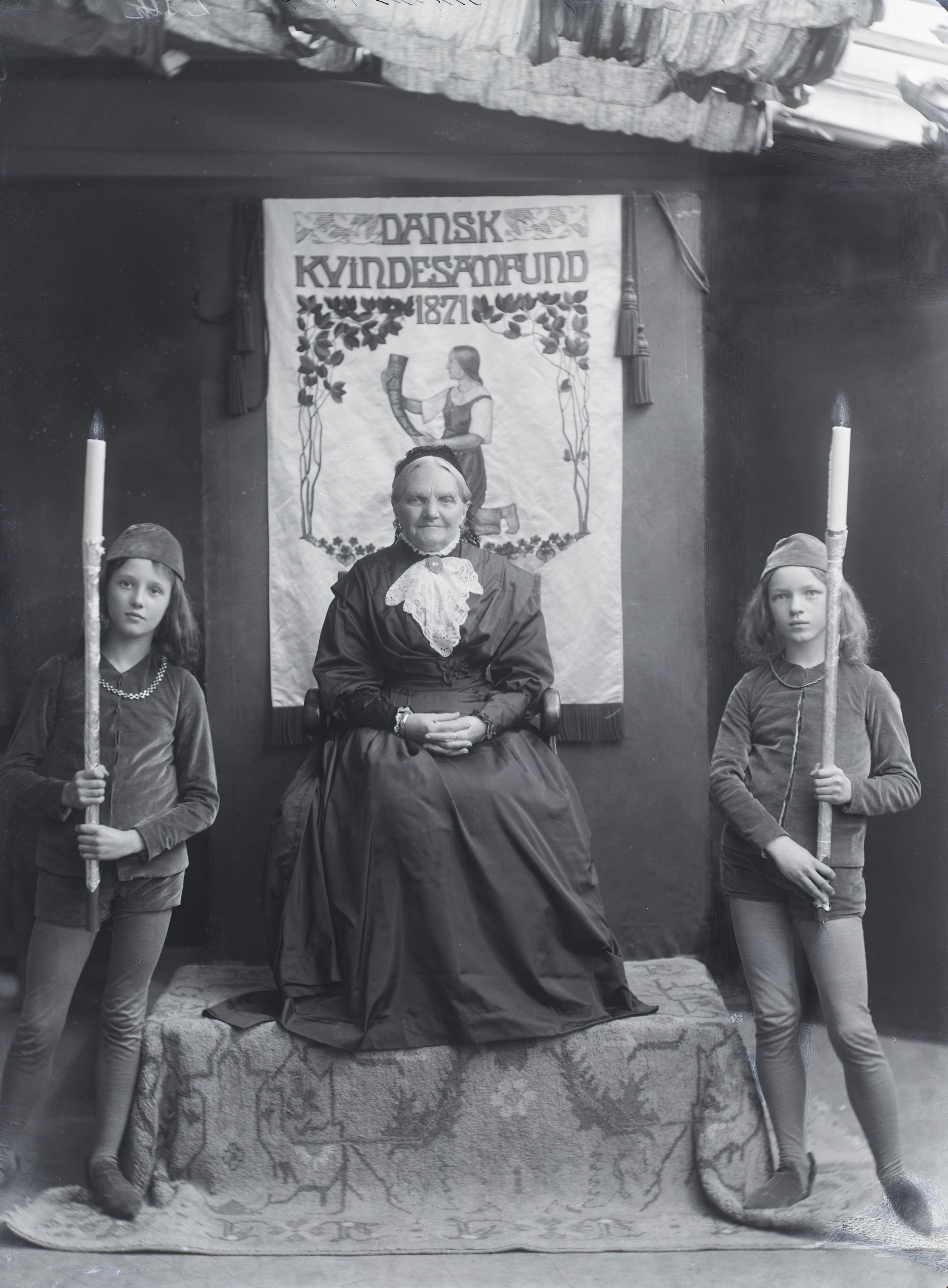 Seated woman with two torch bearers on either side