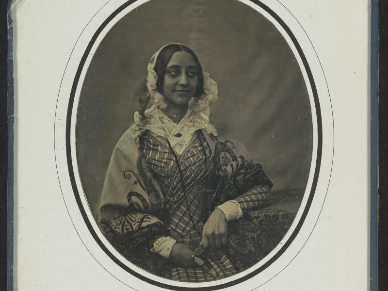 Et mørkt portræt af flot klædt kvinde i 1800-tallet