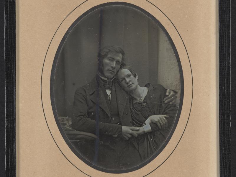 Sort-hvid portræt af mand med armen om sin hustru.