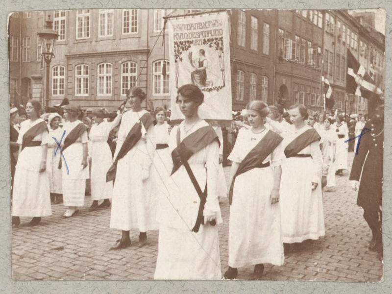 Kvindetoget går mod Amalienborg med bannere og flag.