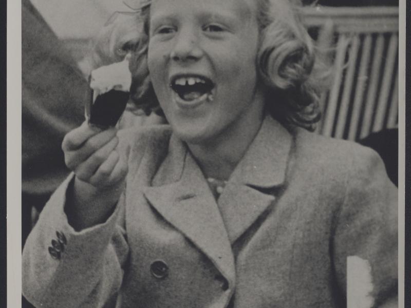 Dronning Margrethe II som barn smiler med sin is.
