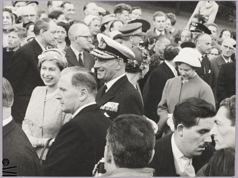 En smilende Elizabeth står med kong Frederik i en folkemængde