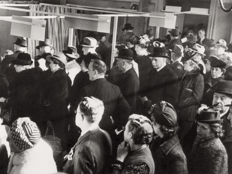 Women and men stand in line at the polls