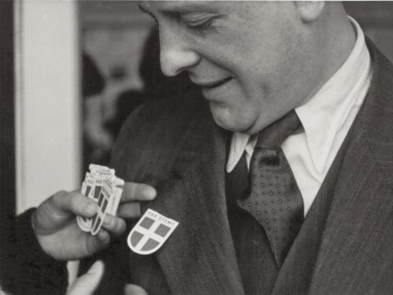 Man gets badge with the text "I voted" and Dannebrog on the jacket