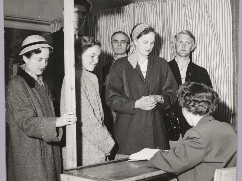 Women are given their ballot papers at the polling station