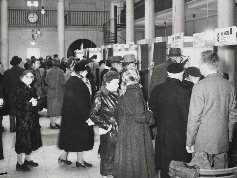 Men and women queuing at the polling booths