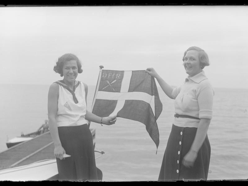 To kvinder holder det danske flag oppe hvor der står DFFR