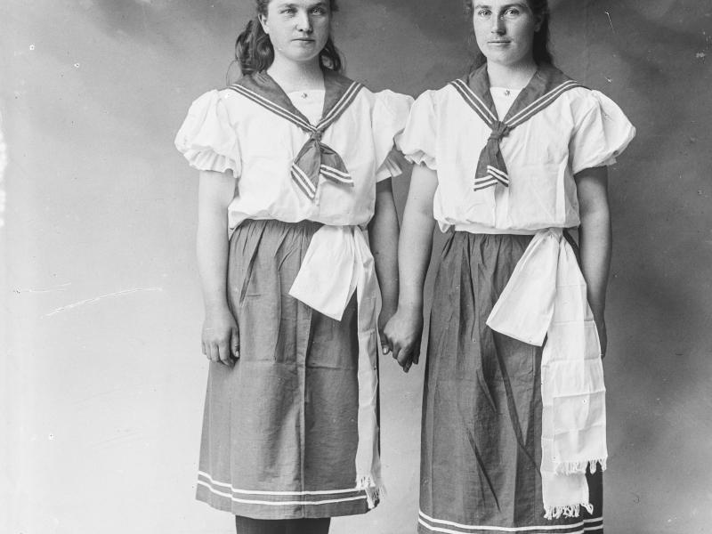 Fotografi af to kvinder iført tidens idrætstøj.