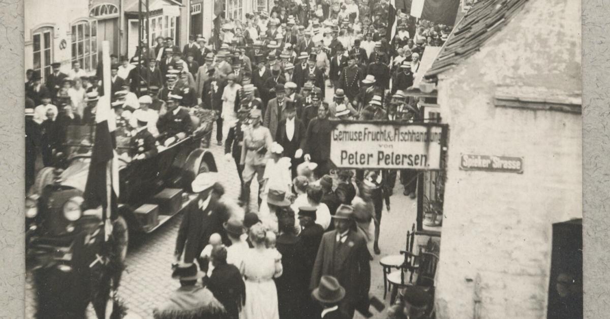 The royal family drives into Tønder. Signs in German.
