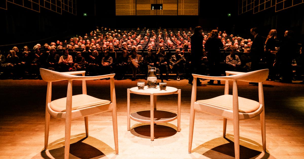 Two chairs on stage for the International Authors' Stage while the audience finds their seats