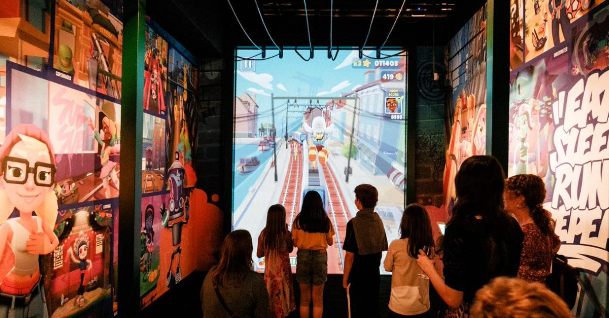 Billede af børn, der spiller computerspiller fra Subway Surfers på en stor skærm.