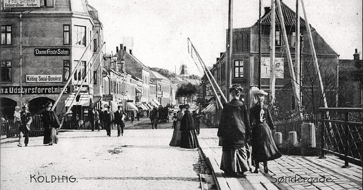 En gade med en masse mennesker og skilte til forretninger.